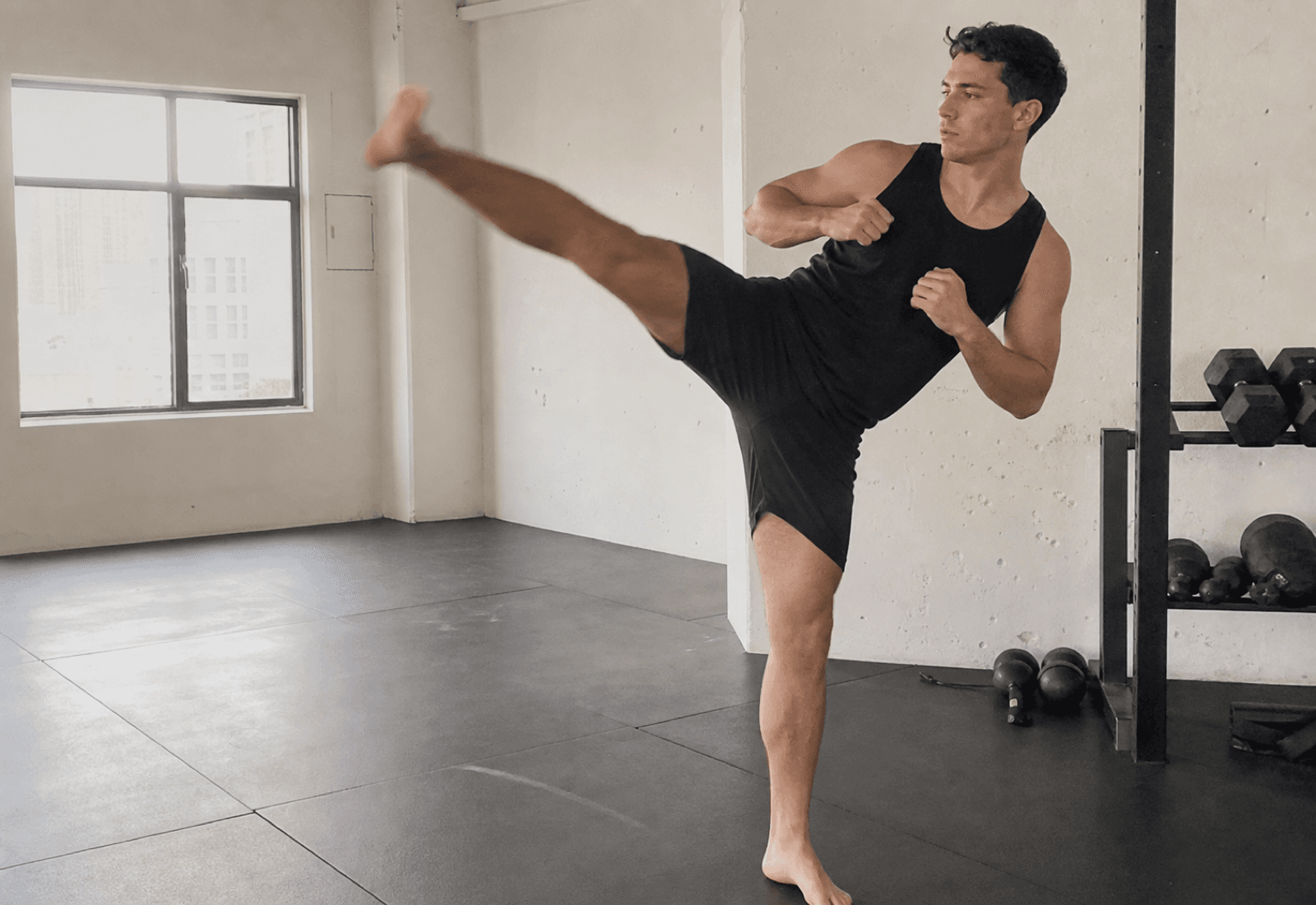 Athlete training a controlled high kick in a clean studio