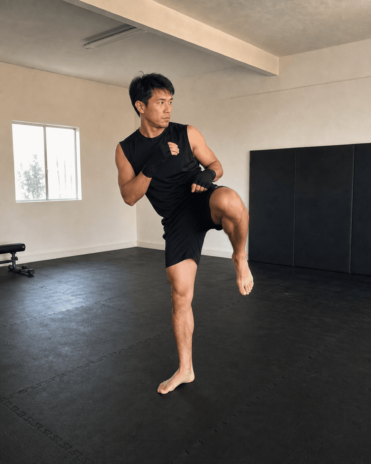 Martial artist practicing chamber position in a bright training studio