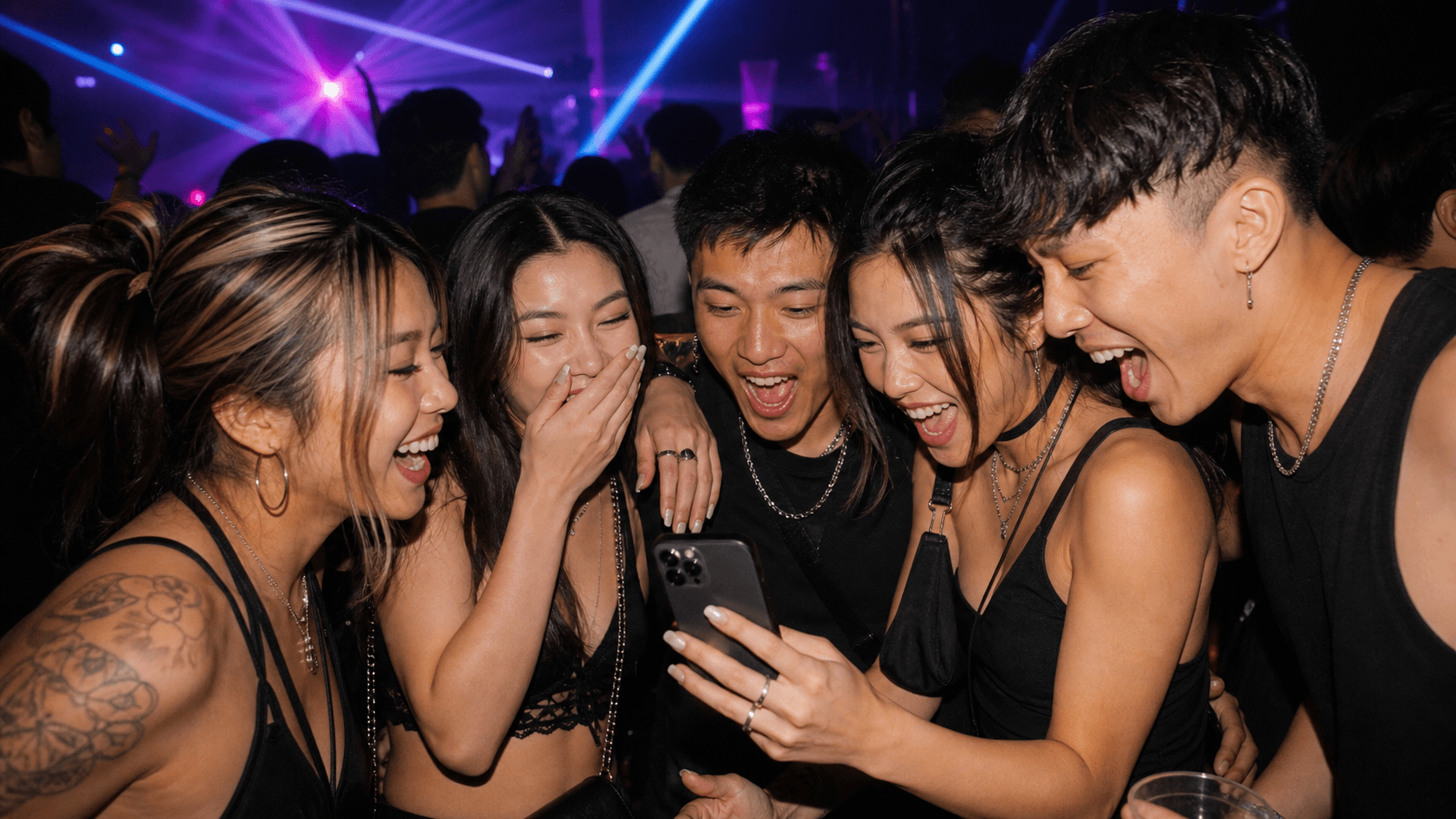 People smiling at a night party while using a phone